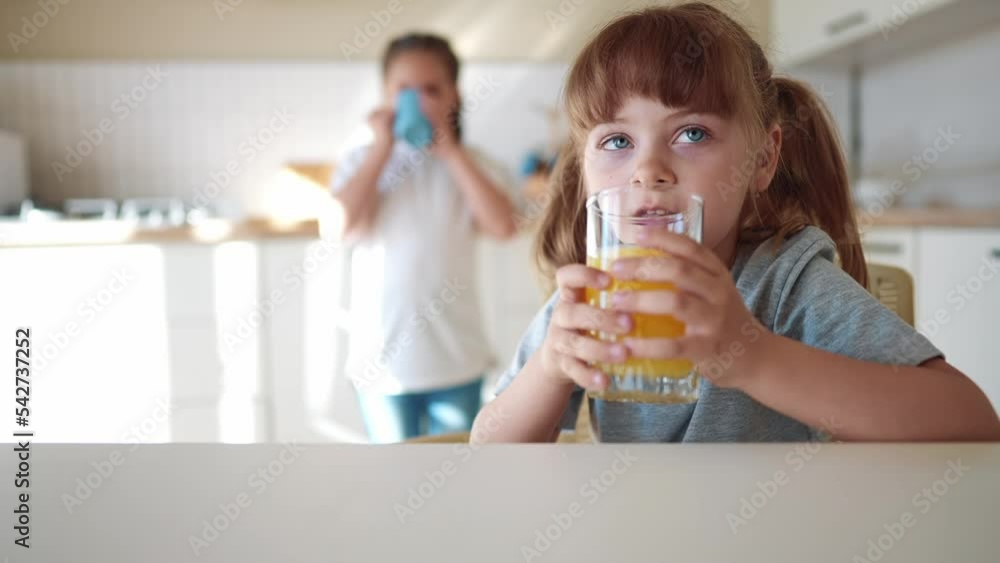 children drink juice. little girl in the kitchen drinking yellow juice from a glass cup. happy family kid dream concept. children drink juice in the kitchen. lifestyle healthy eating concept children drink juice. little girl in the kitchen drinking yellow juice from a glass cup. happy family kid dream concept. children drink juice in the kitchen. lifestyle healthy eating concept