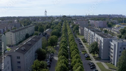 Passing over green alley street with threes in small European town aerial view