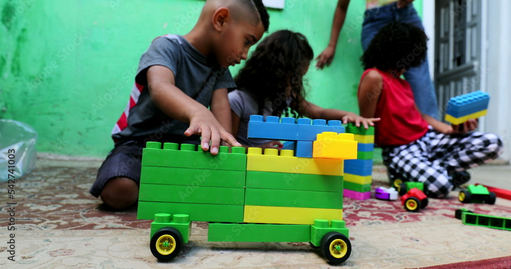 Hispanic children playing home with toys Hispanic children playing home with toys