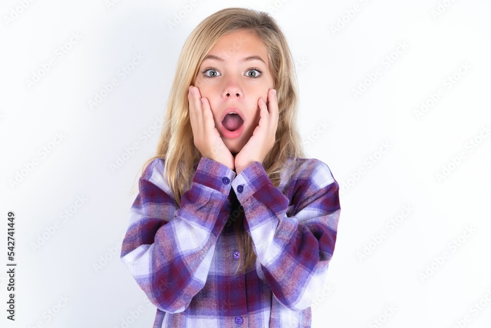 Scared terrified beautiful caucasian teen girl wearing plaid purple shirt over white wall shocked with prices at shop, People and human emotions concept Scared terrified beautiful caucasian teen girl wearing plaid purple shirt over white wall shocked with prices at shop, People and human emotions concept