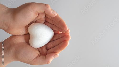 boy holding white heart in palm. Organ donation and insurance concept. World heart health concept. World organ donation day. Concept of healthy heart for healthy life. selective focus