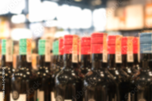 Blur liquor store background. Many blurred bottles with alcohol. Wine bottles background with copy space photo