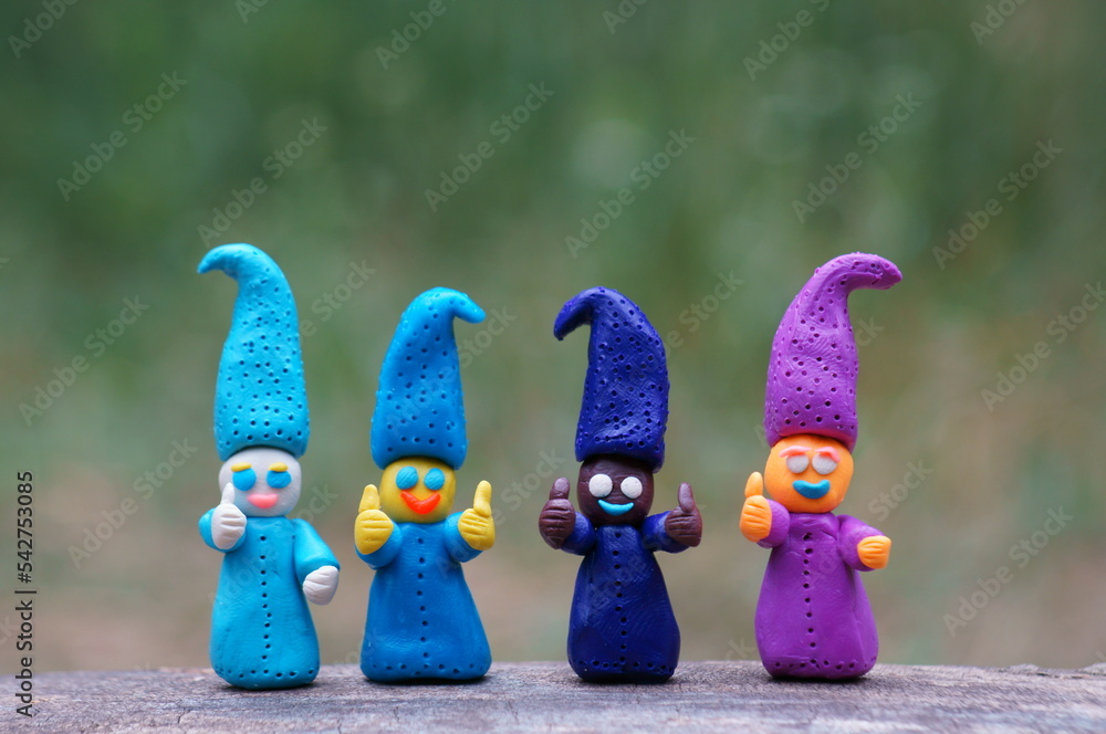 Figures of four colorful dwarfs with thumbs up. Positive mood. Well-being and love. Fairy-tale characters.
