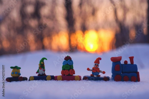 Toy train with Christmas toys on the background of the sunset.