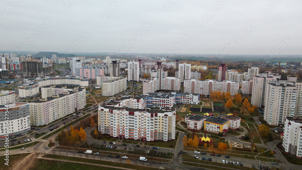 Fototapeta premium Multi-storey buildings with infrastructure. Densely populated urban area. Overcast weather. Autumn landscape. Aerial photography.