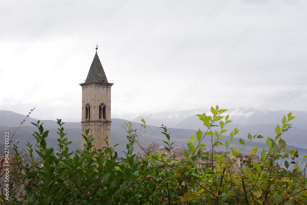Pacentro - Abruzzo - Italy - Detail of the bell tower of the mother church with the background of the Peligna valley in autumn Pacentro - Abruzzo - Italy - Detail of the bell tower of the mother church with the background of the Peligna valley in autumn