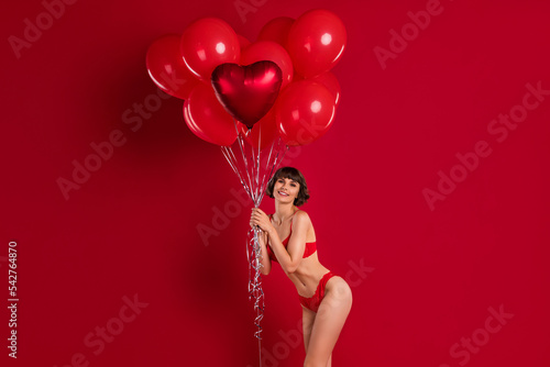 Portrait of attractive cheerful chic girl holding helium balls shop opening store gift present isolated on bright red color background
