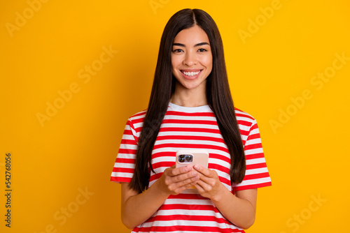 Photo of pretty positive black hairdo person hold use telephone toothy smile wear red white stripes isolated on yellow color background