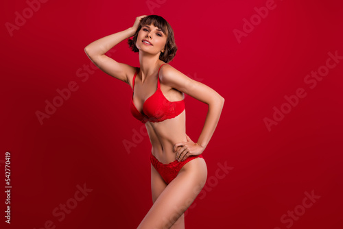Portrait of attractive cheery confident fit nude girl posing enjoying isolated over bright red color background