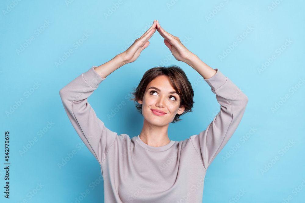 Photo of brown hairdo young lady arms roof wear grey sweatshirt isolated on blue color background