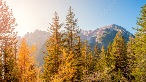 Magical Dolomite peaks at the national park Three Peaks, Tre Cime, in Autumn colors during sunset direct sunlight at blue sky, South Tyrol, Italy, golden season
