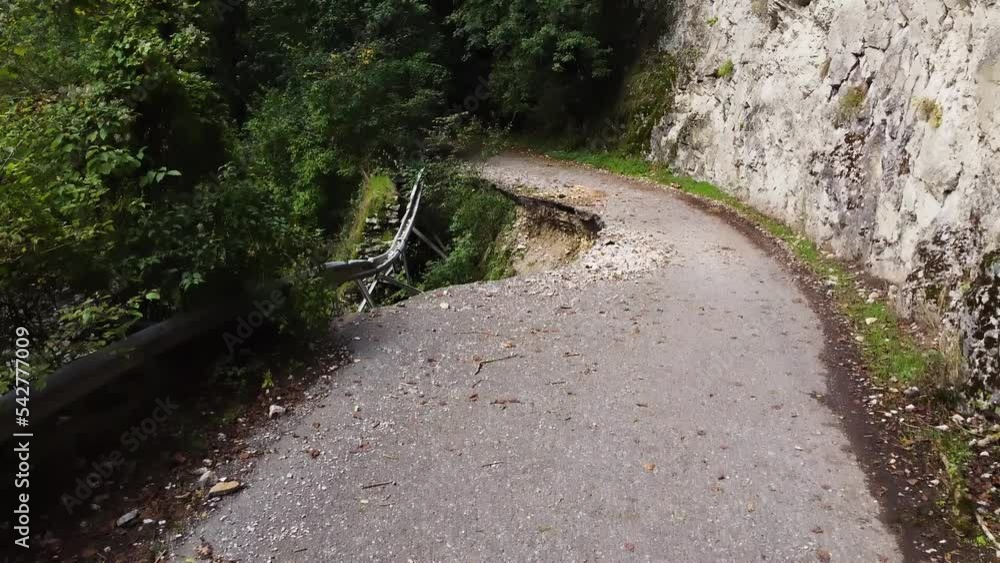 An old abandoned highway in the mountains, and, a mountain river in a gorge. Aerial view, from a drone. Summer cloudy day.
