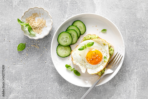 Avocado toast with fried egg for breakfast, healthy food, overhead view photo