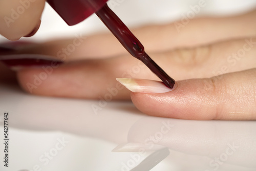 woman applies nail polish