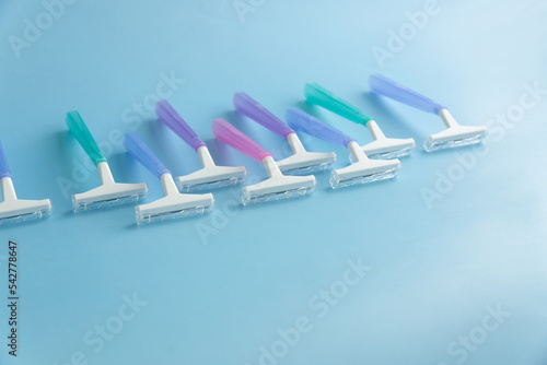 Set of multi-colored disposable razors on a blue background.