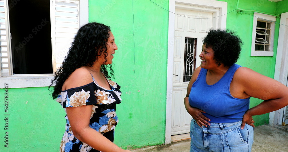 Naklejka premium Hispanic women gossiping in emotional conversation. Latinas talk