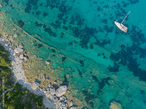 Aerial view of a boat moored near the coast of the island of Corfu, crystal clear sea. Greece
