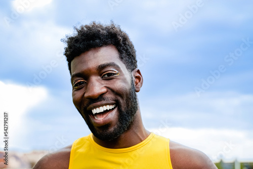Gay queer African man wearing makeup smiling at camera outdoor - Nonbinary and transgender Lgbtq community concept