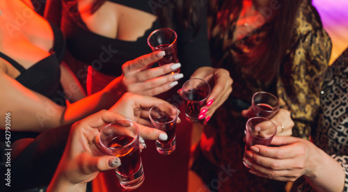 фотографія Clinking glasses with alcohol and toasting, party.
