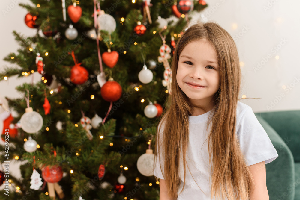 Cute girl in pajamas on the background of the Christmas tree