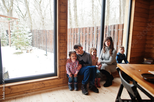 Mother and kids in modern wooden house with table, spending time together in warm and love.