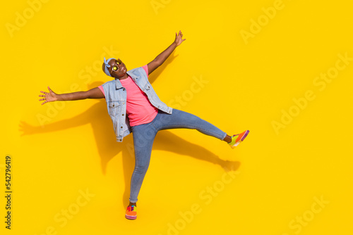Full length photo of overjoyed carefree lady raise opened hands dancing isolated on yellow color background