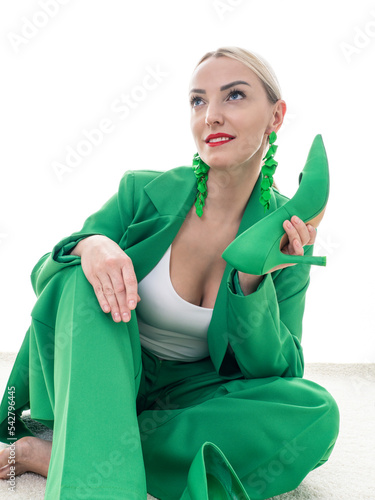 Fashion shot. Green total look. A beautiful blonde woman poses on a white background. Beauty, fashion concept.
