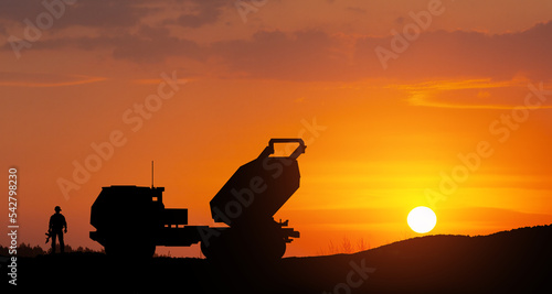 Artillery rocket system are aimed to the sky and soldier at sunset. Multiple launch rocket system. © hamara