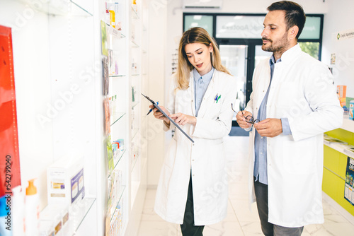 Male and female pharmacy workers working together in pharmacy store