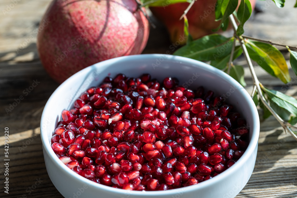 Raw pomegranate (Punica granatum) seeds ready to be eaten. Close up on pomegranate arils with fruits in the background. Raw pomegranate (Punica granatum) seeds ready to be eaten. Close up on pomegranate arils with fruits in the background.