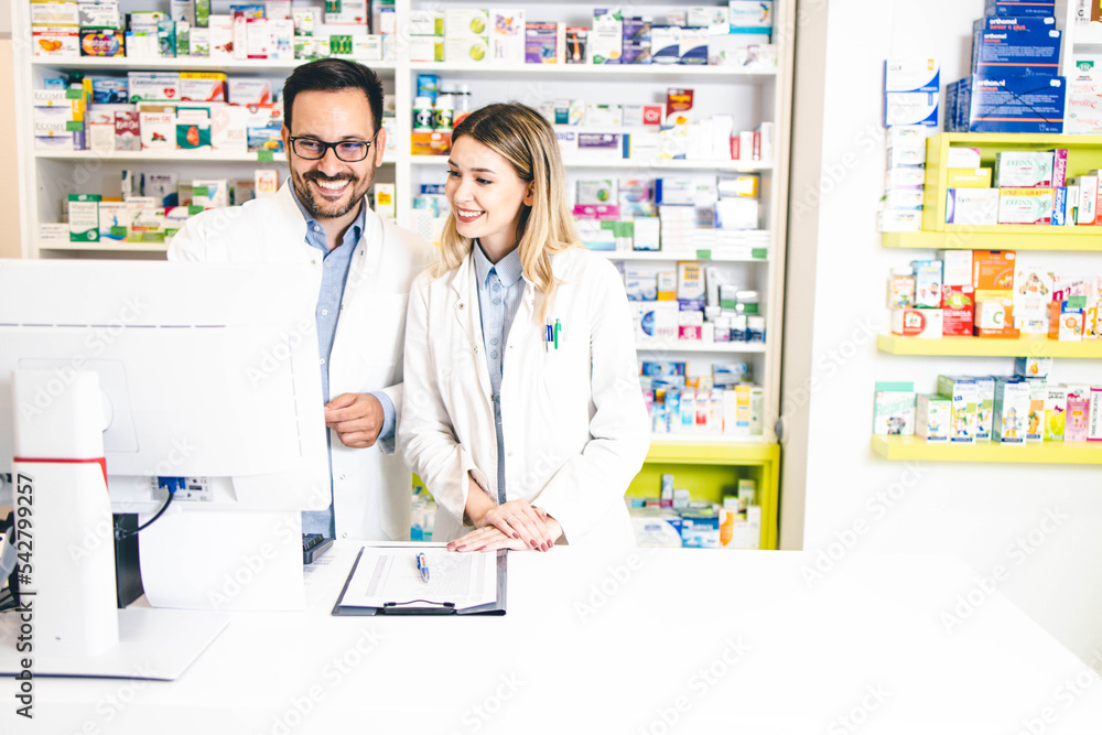 Male and female pharmacy workers working together in pharmacy store