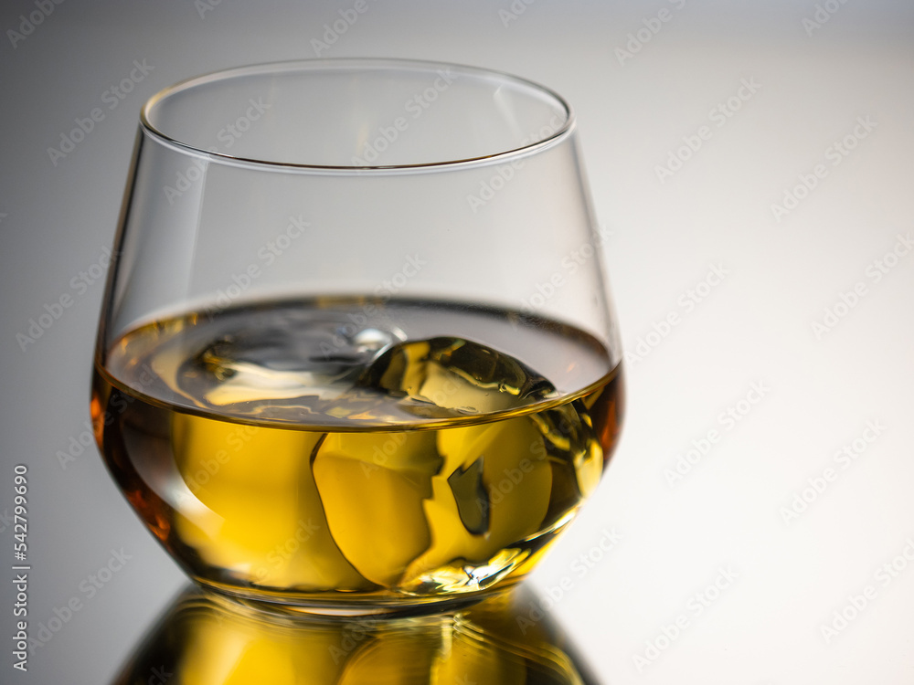 Whisky on the rocks, glass filled with ice cubes, close-up shot
