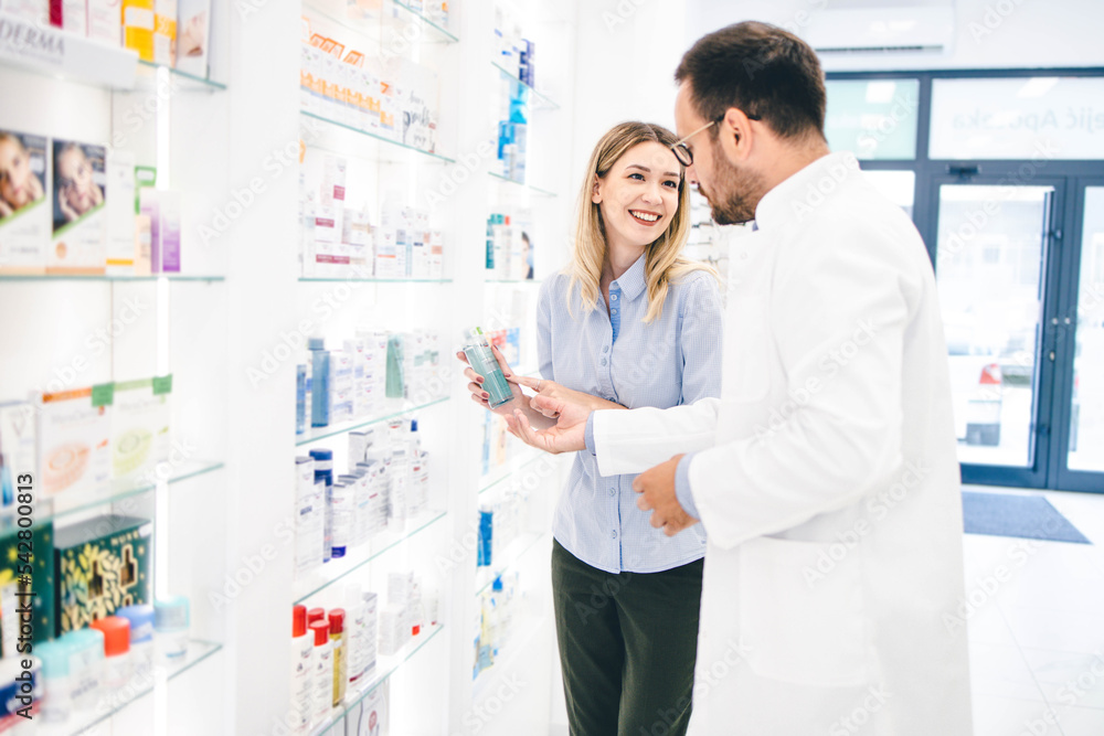 Young man working in pharmacy
Helping his client to pick up best products
Pharmacist recomending products