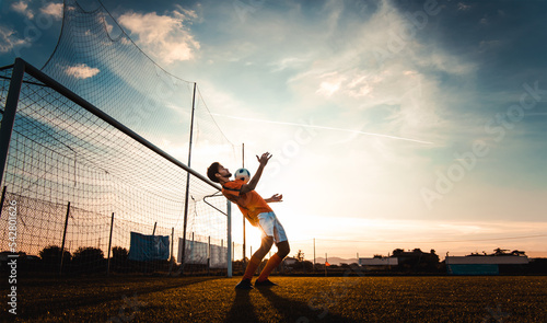 Soccer player in action on the soccer stadium - Man playing football on sunset - Football and sport championship concept photo