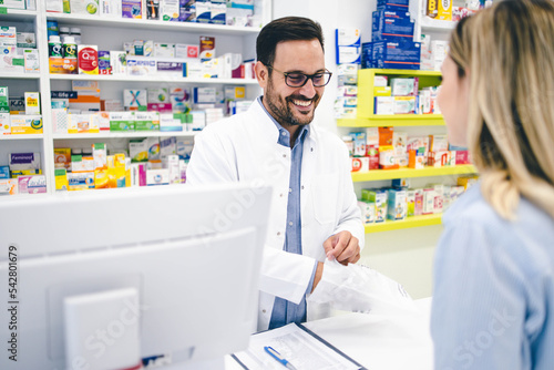 Pharmacy worker and customer stock photo Customer buying some pharmacy products