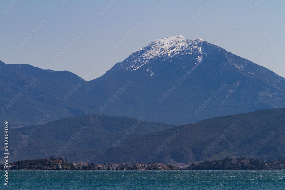 landscape photo taken from the shore.
(snowy mountain, sea, beach, pebble,residential area,  forest...)