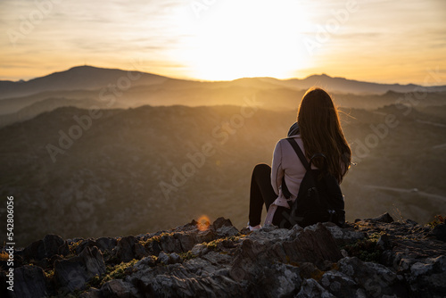 Beautiful women sitting on a rock during sunset on the mountains photo