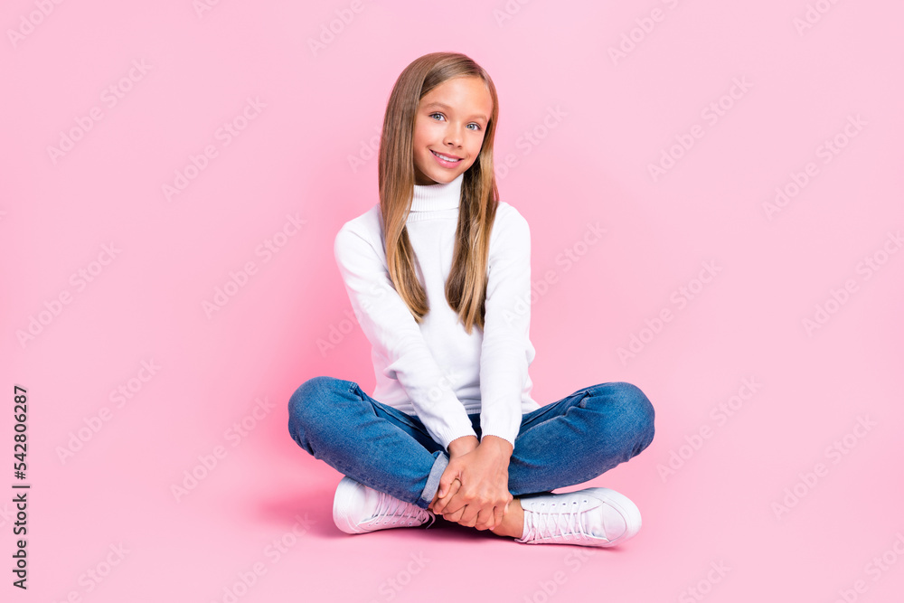 Full size photo of cheerful adorable person sit floor crossed legs isolated on pink color background Full size photo of cheerful adorable person sit floor crossed legs isolated on pink color background