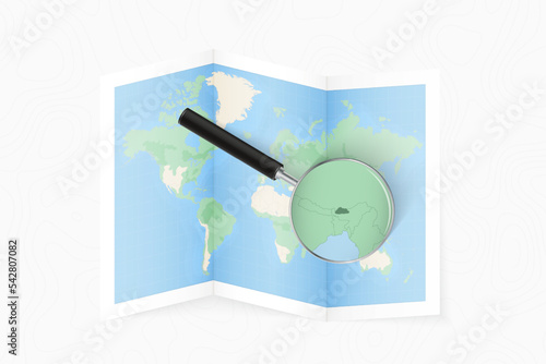 Enlarge Bhutan with a magnifying glass on a folded map of the world.