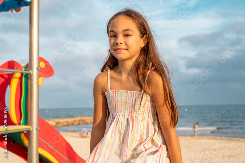 Little cute child girl in playground on the beach with smile on summer vacation. Happy children kid enjoy and fun outdoor activity lifestyle