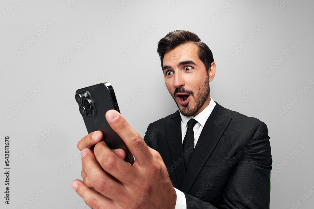 Man businessman in suit holding phone in hand on phone posing in front of  smartphone camera