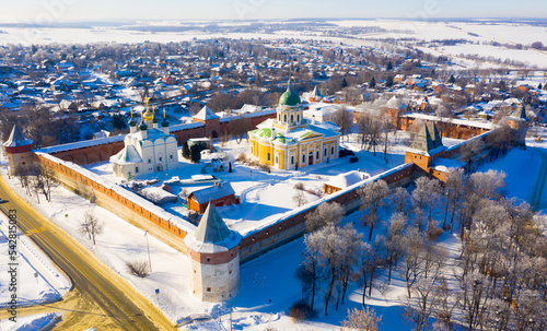 View from drone of snow covered architectural ensemble of Zaraysk Kremlin with Forerunner and St. Nicholas cathedrals on winter day, Russia