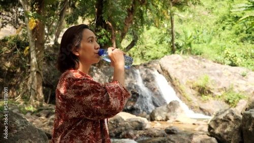 Asia woman enjoying in the forest at Salika waterfall Thailand photo