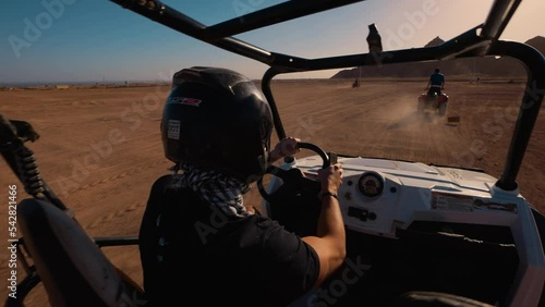 Libyan desert in Egypt. Sharm El Sheikh. Buggy desert safari. A driver in a motorcycle helmet drives a buggy.