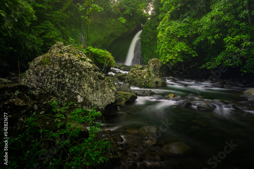 Indonesian landscape photo with waterfall in the morning and beautiful green tropical forest