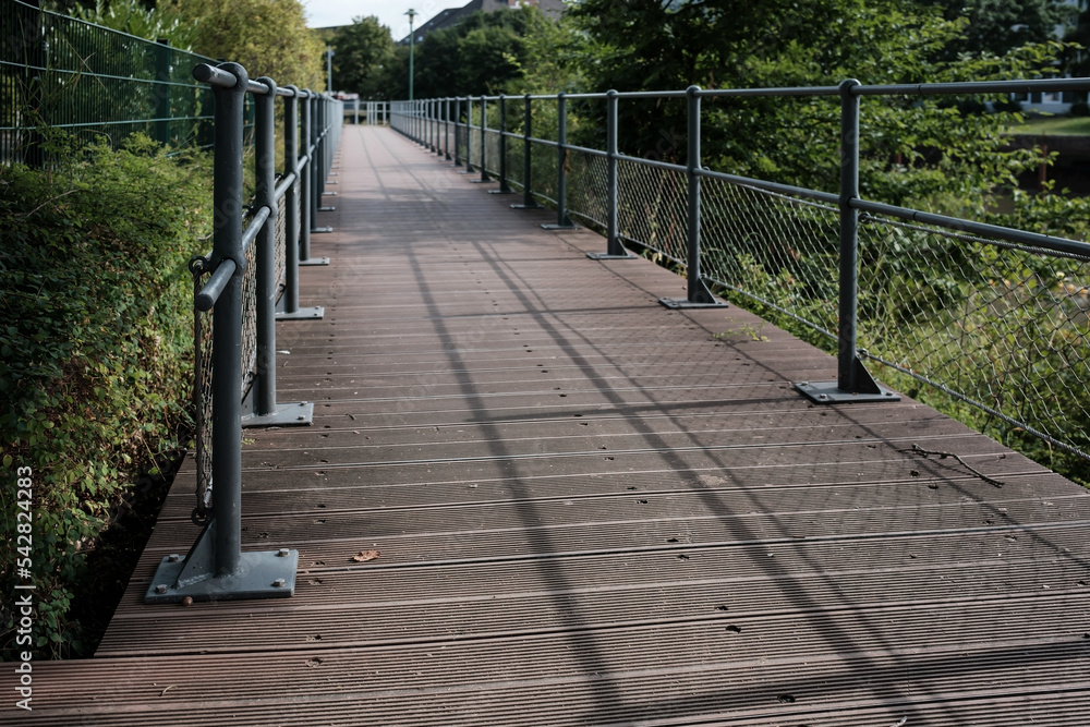 Wooden walkway with metal railings for a safe walk in the park.