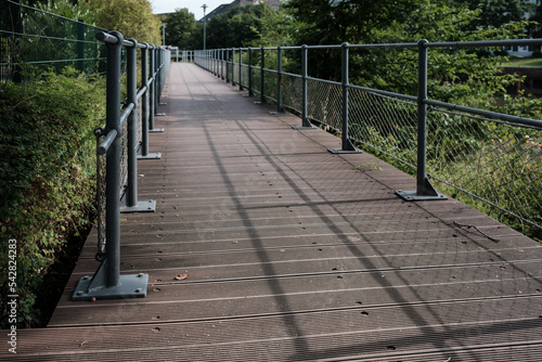 Wooden walkway with metal railings for a safe walk in the park.