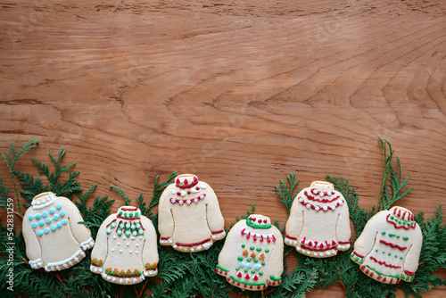 Foto Homemade ugly sweater Christmas cookies framing bottom of wooden background