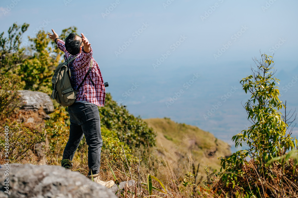 Young trekking man standing rocky mountain peak