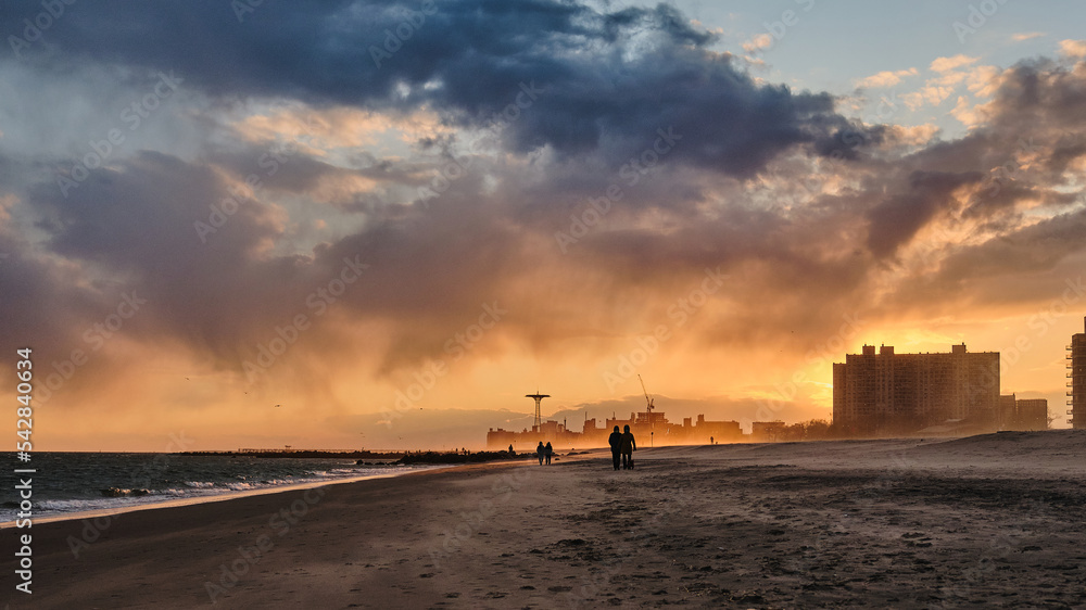 Sudden sand storm on the beach at Coney Island at Sunset with masked passerby people Sudden sand storm on the beach at Coney Island at Sunset with masked passerby people